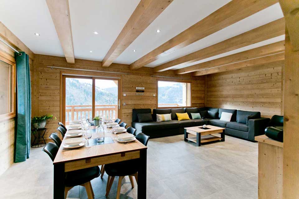 Grande pièce à vivre très lumineuse avec baies vitrées et vue sur la chaine des Aravis photo arvimedia 